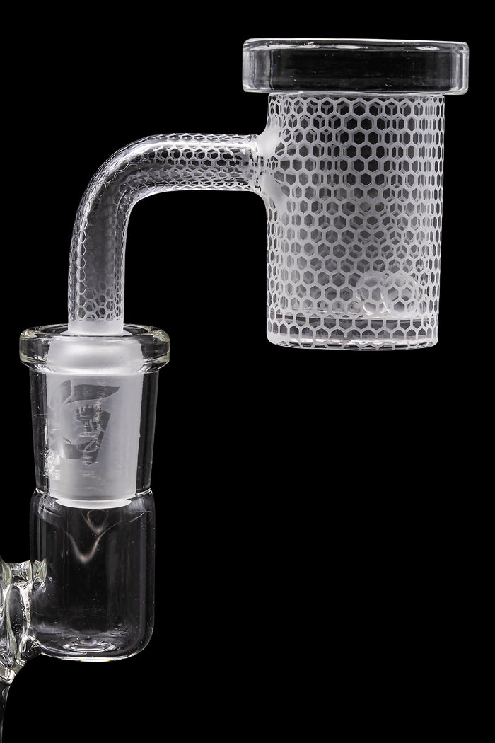 Frosted glass dab rig with a honeycomb perc chamber, isolated on a black background.