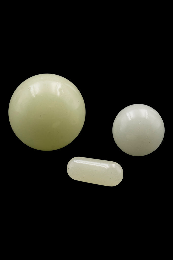 Green cannabis capsules and pills isolated on a black background.