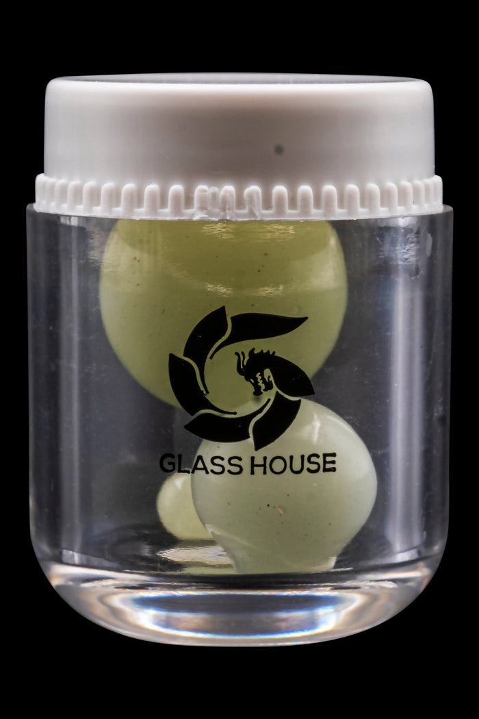 Clear glass jar filled with olive green cannabis concentrate, branded with a black "Glass House" logo.
