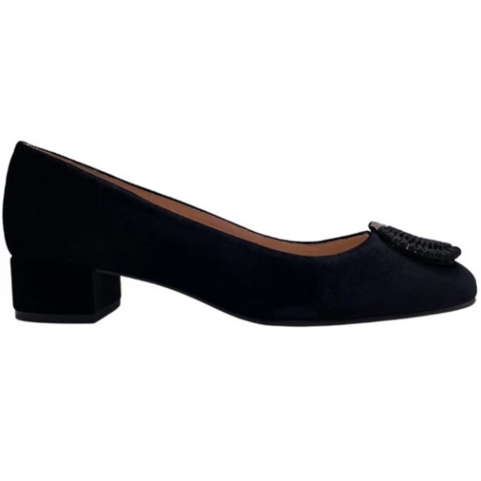 Black velvet pump with a rounded toe, block heel, and a silver buckle wrapped in black detailing on the toe box side view