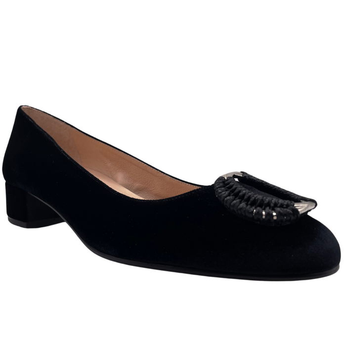 Black velvet pump with a rounded toe, block heel, and a silver buckle wrapped in black detailing on the toe box angle view