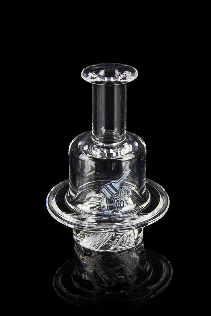 Clear glass dab rig with intricate sculpting, isolated on a black background.