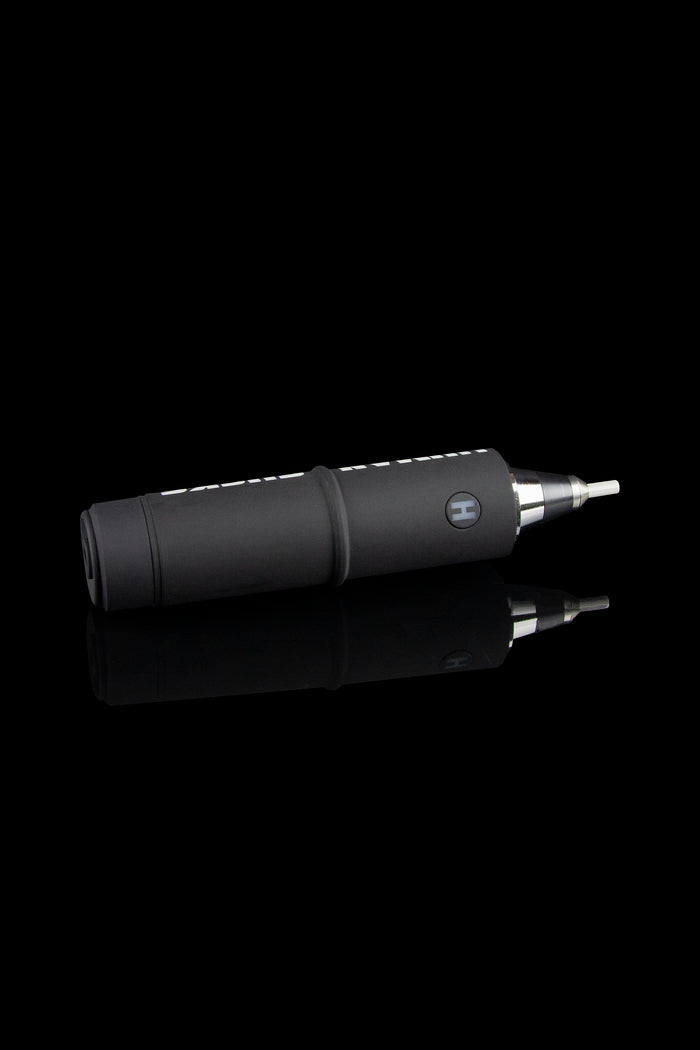 Black electronic dab rig with metallic tip, reflected on a dark surface.