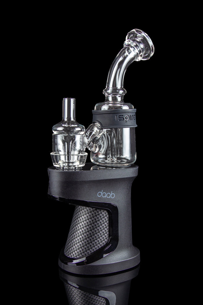A close-up, angled view of the Ispire Daab E-Rig featuring a dark-colored base and a clear glass bubbler attachment.