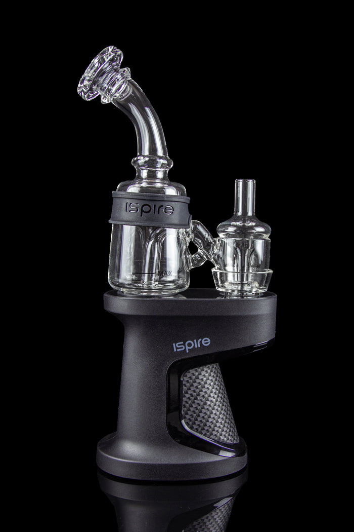 A black “Inspire” branded cannabis oil rig with glass water pipes and attachments, isolated on a black background.