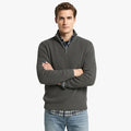 Homme portant un pull en laine bordeaux avec fermeture éclair, chemise à carreaux bleue et jean décontracté. Mode automne-hiver élégante et confortable.
