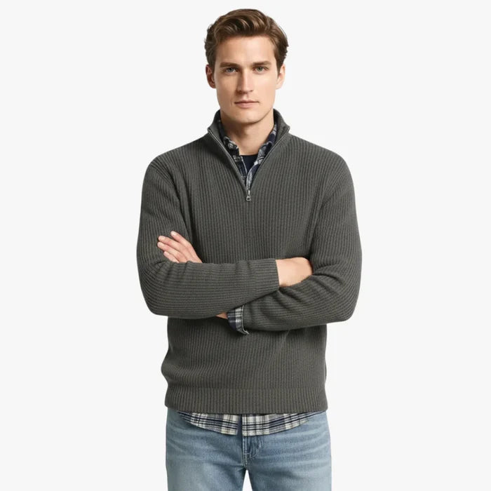 Homme portant un pull en laine bordeaux avec fermeture éclair, chemise à carreaux bleue et jean décontracté. Mode automne-hiver élégante et confortable.