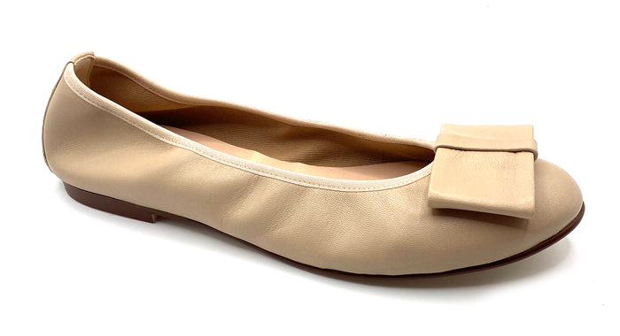 Beige leather ballet flat with a rounded toe and a large folded bow accent on the front. Angle view