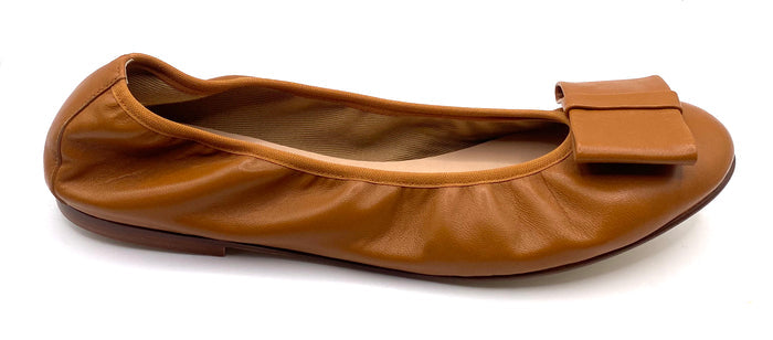 Brown leather ballet flat with a rounded toe and a large folded bow accent on the front. Side View