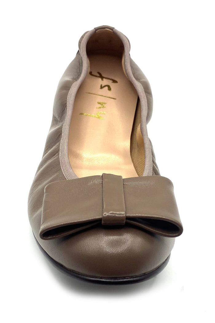 Taupe leather ballet flat with a rounded toe and a large folded bow accent on the front. Front View