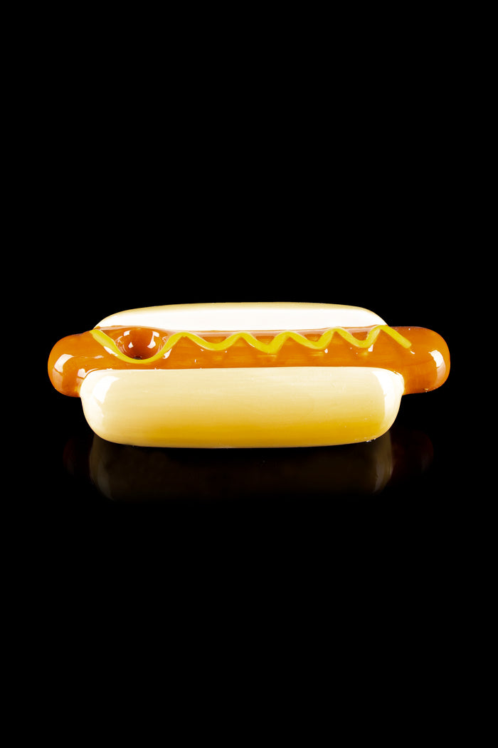 Glass pipe shaped like a hot dog with mustard.
