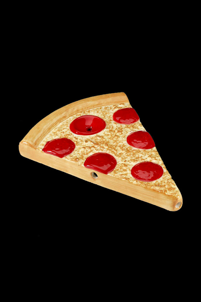 A ceramic pizza slice pipe with glossy red "pepperoni" details.