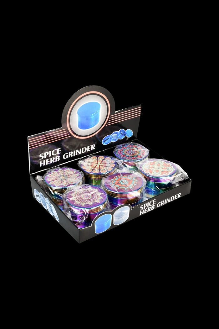 A box displays a 6-pack of Mandala Anodized Grinders, showcasing their colorful, patterned tops in a diagonal arrangement.