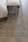Willa patterned power loomed area rug on a wooden floor with a bed and bench in the background